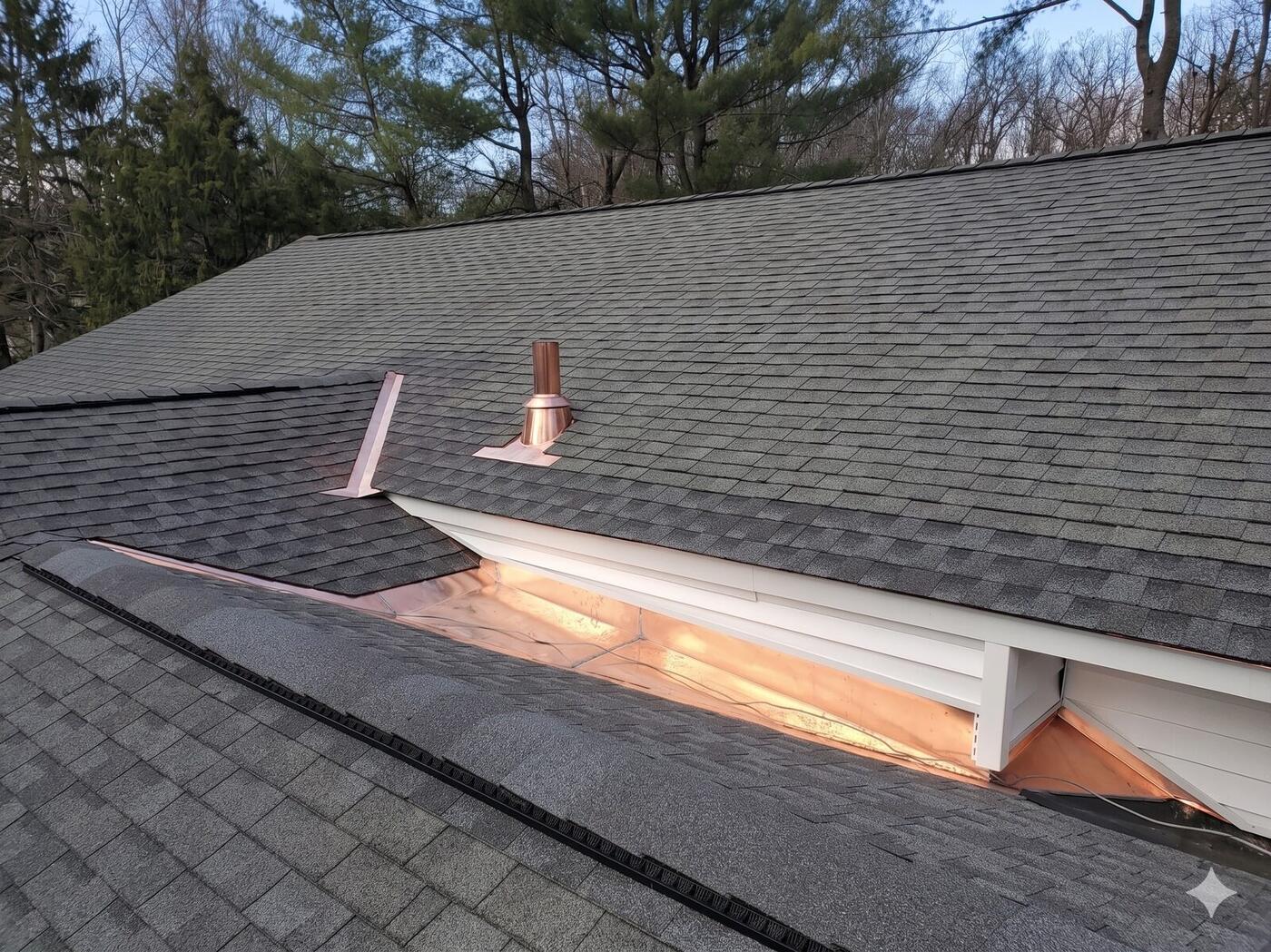A finished asphalt shingle roof at dusk